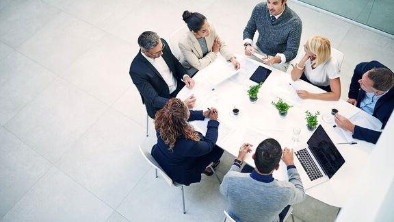 Group of corporate colleagues sitting in the boardroom during a meeting.