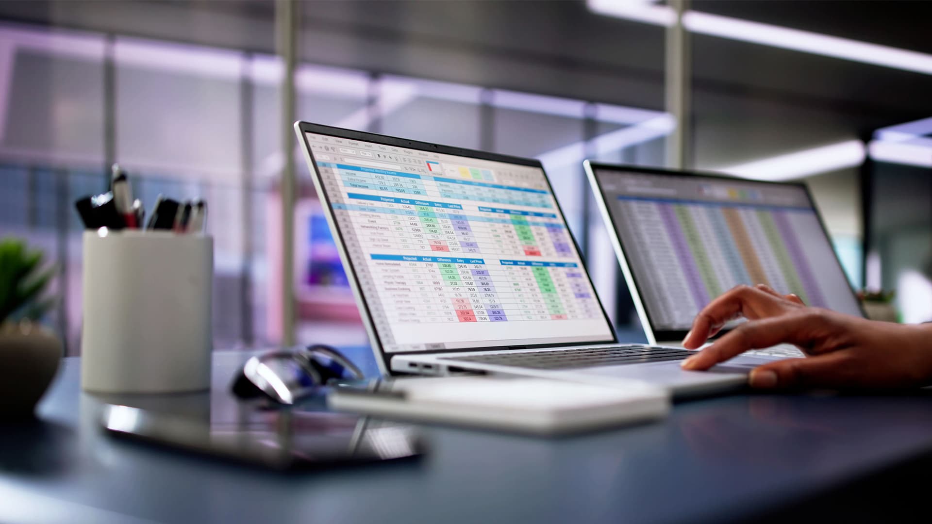 A woman at her laptop looking at excel documents.