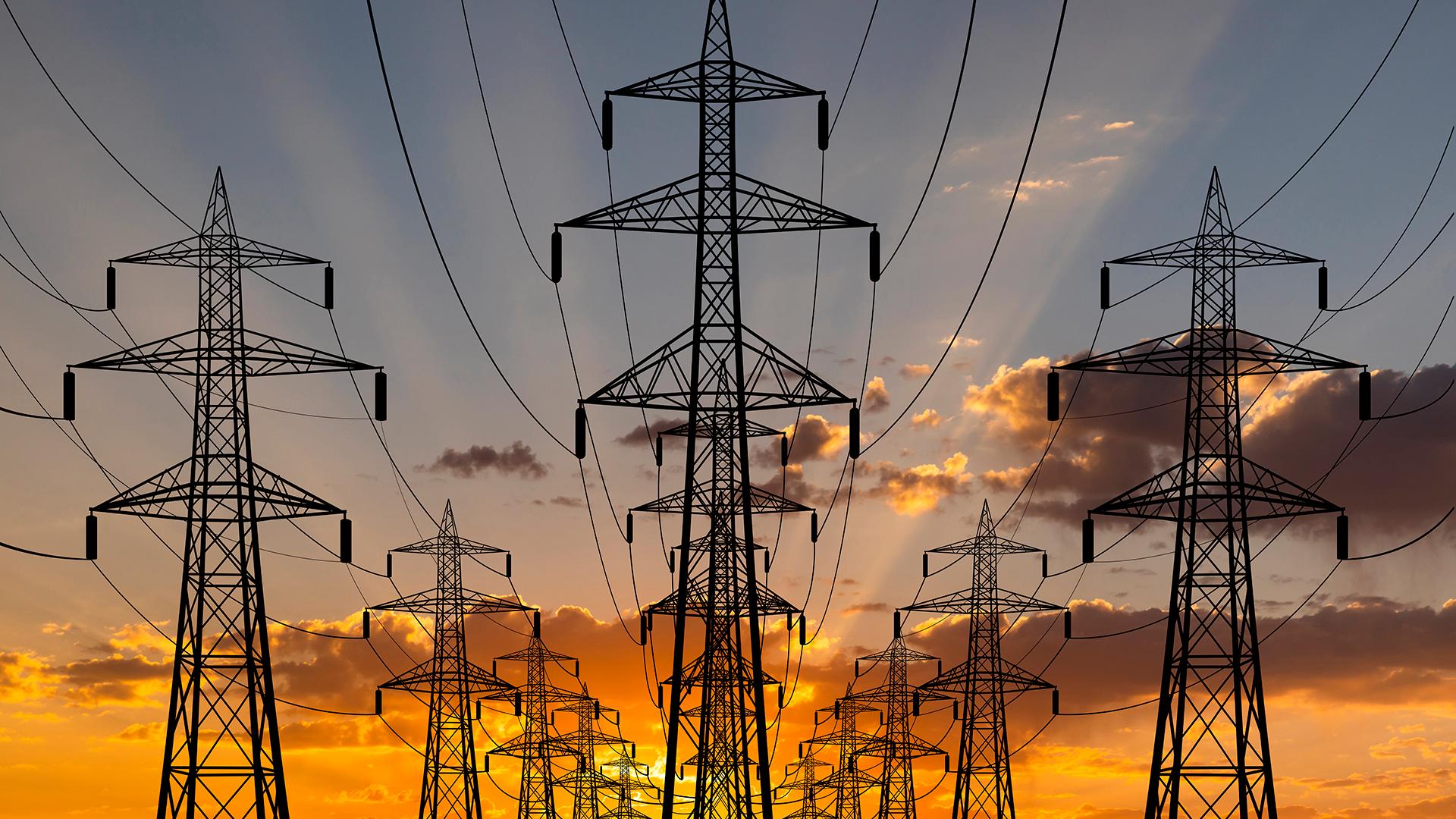  High voltage towers at sunset background.