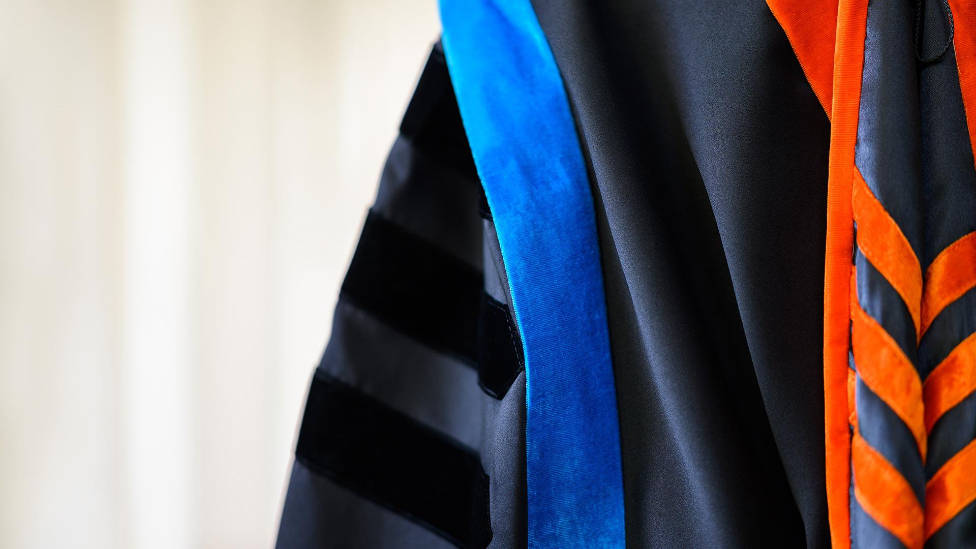A close up of a PhD graduation gown with ornate designs.