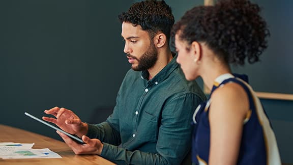 Man and woman looking at a tablet in an office.