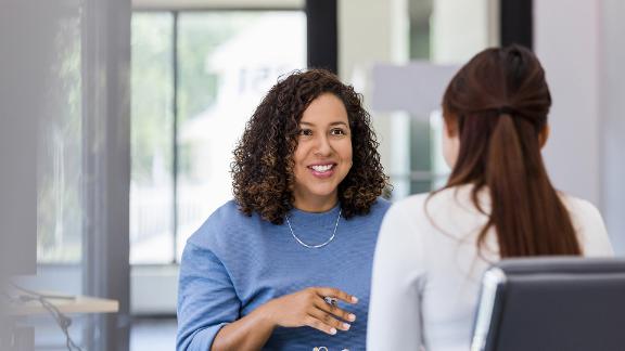 Two professionals talking one on one in an office.