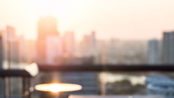 A rooftop looking over the city with the sun setting in the background