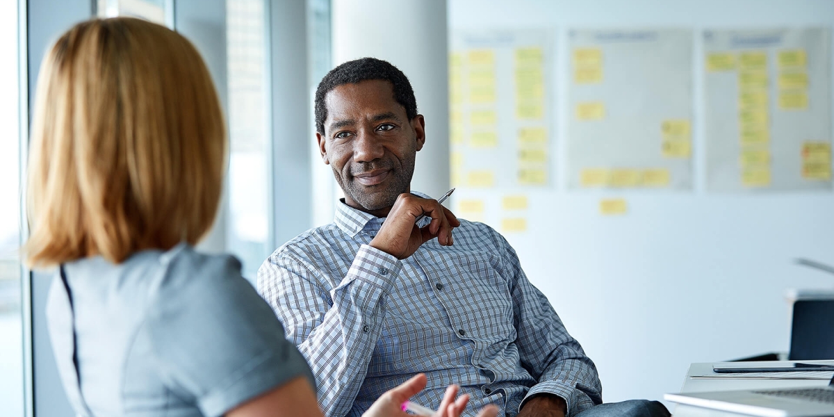 Shot of two colleagues talking together in a modern office