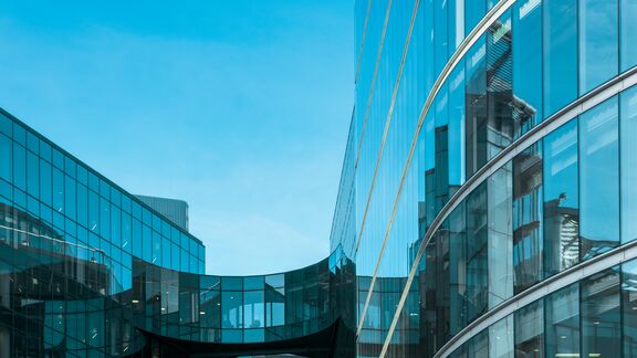 View of contemporary financial building exterior in More London against blue sky.