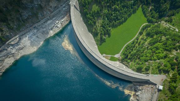 A dam surrounded by a mountain and a green landscape