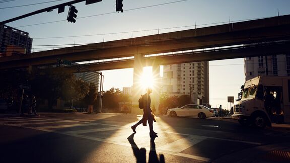 A person who is crossing a road during sunset in Miami, Florida