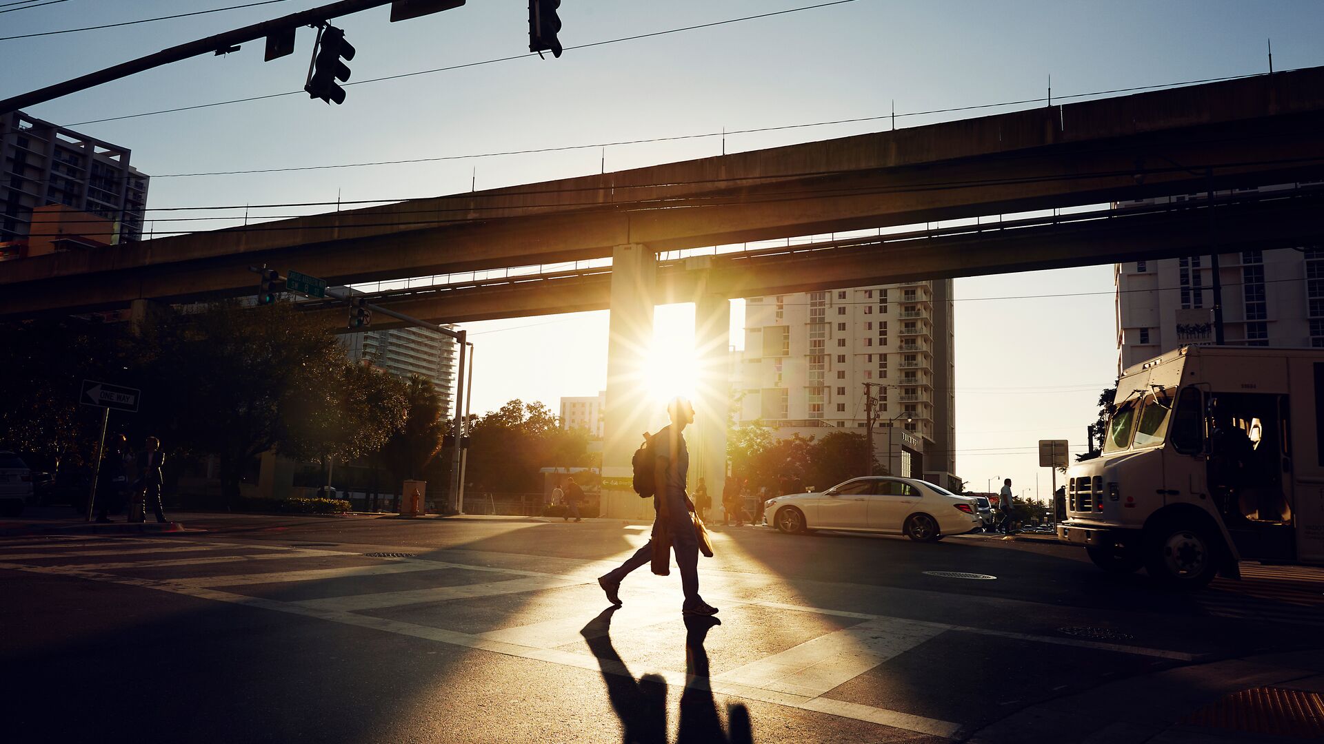 A person who is crossing a road during sunset in Miami, Florida