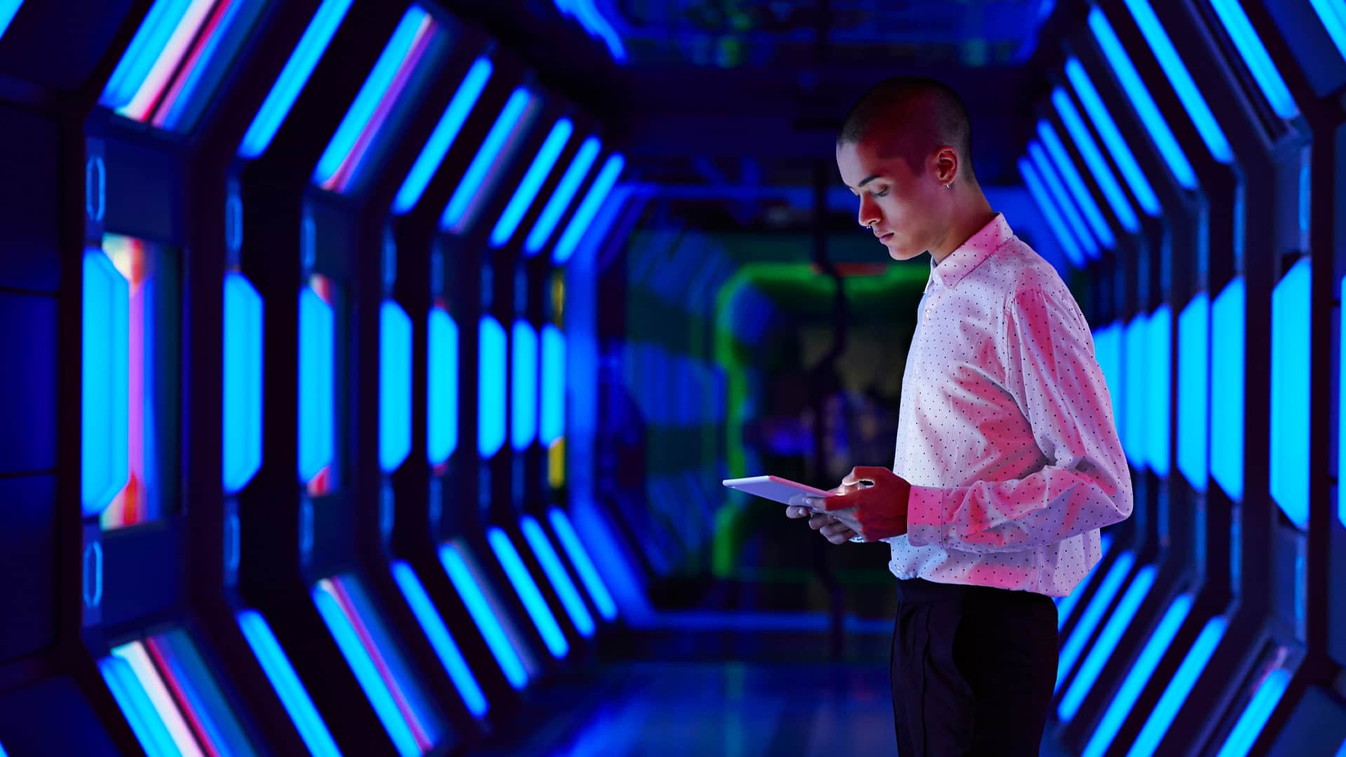 Young businessman looking at digital tablet in spaceship like corridor