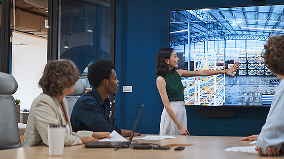 A woman giving a presentation to a small group of colleagues.