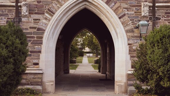 An arched outdoor hallway on a university campus.