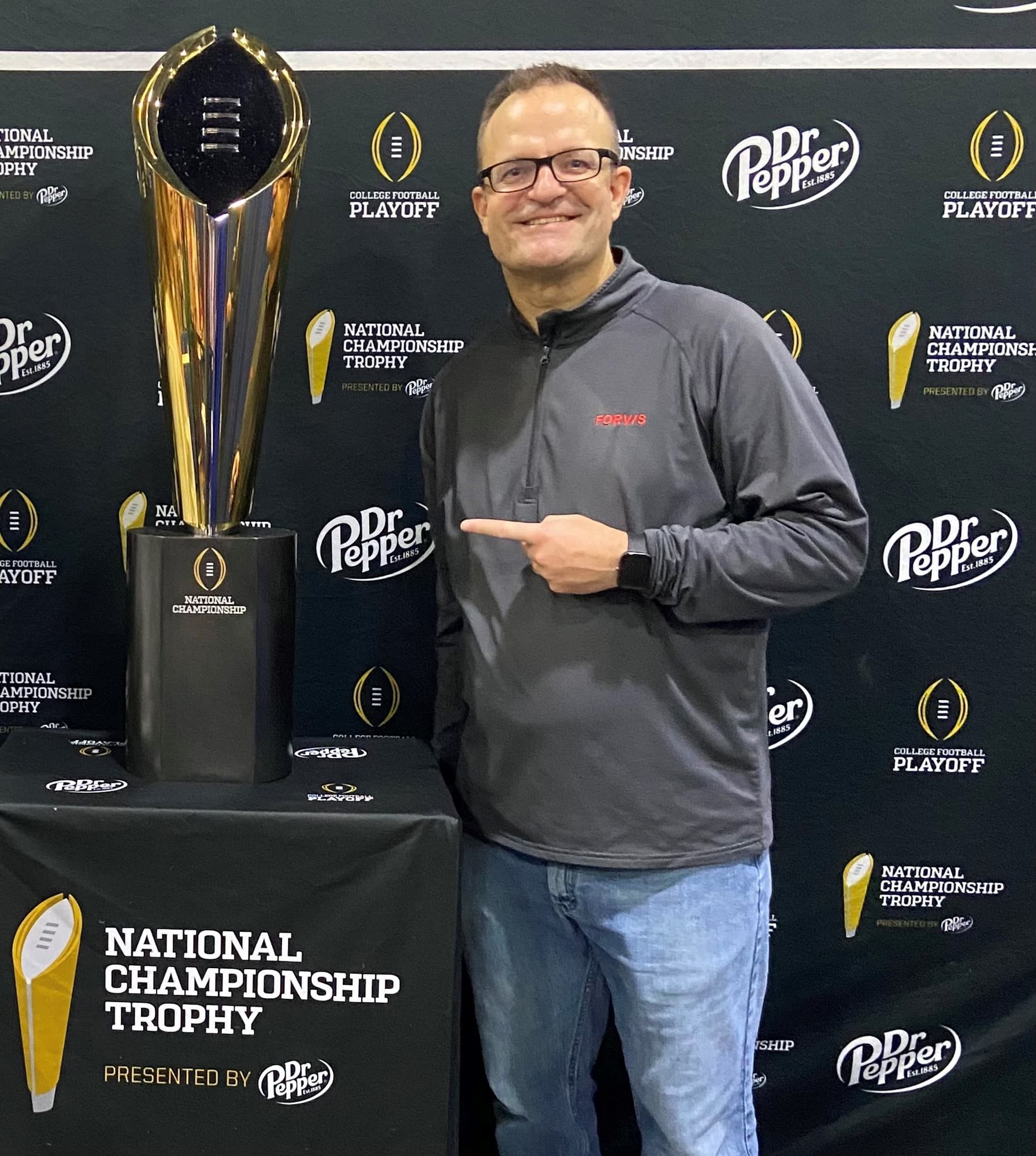 Ed standing next to the college football trophy.