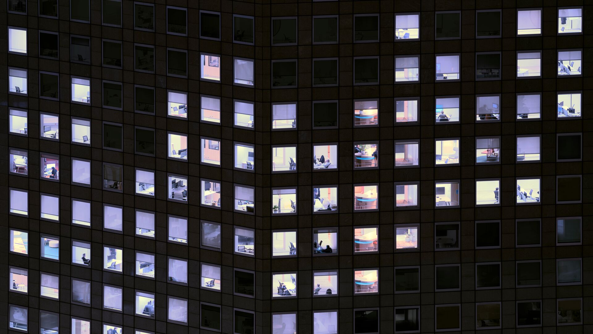 A building with specific lit up windows to create a zig zag pattern.