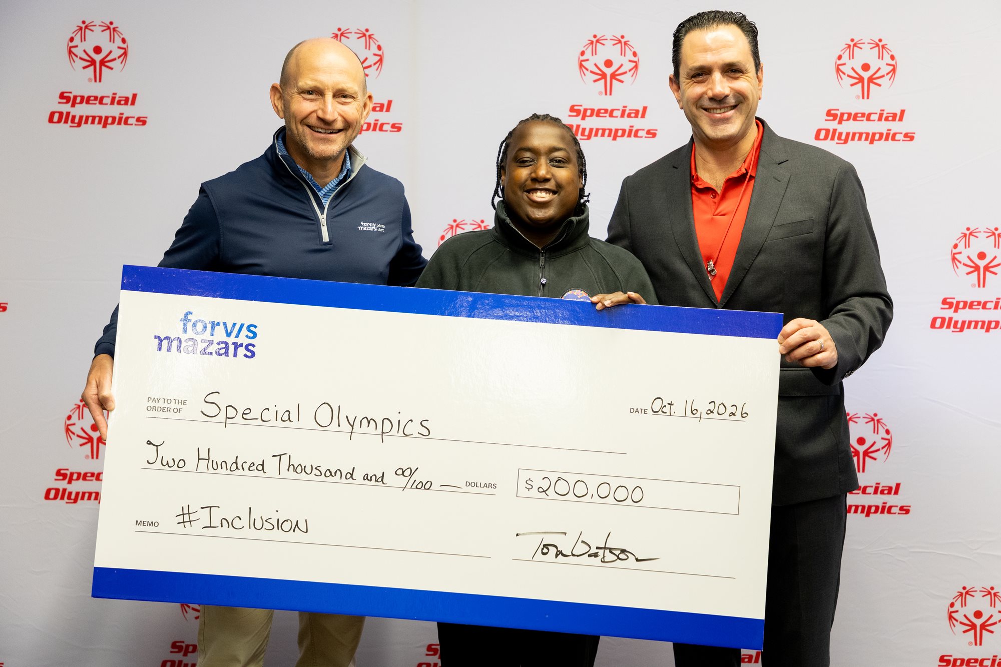 Forvis Mazars CEO Tom Watson, Special Olympics athlete Novie Craven, and Special Olympics Global CEO David Evangelista taking a picture while holding a large check.