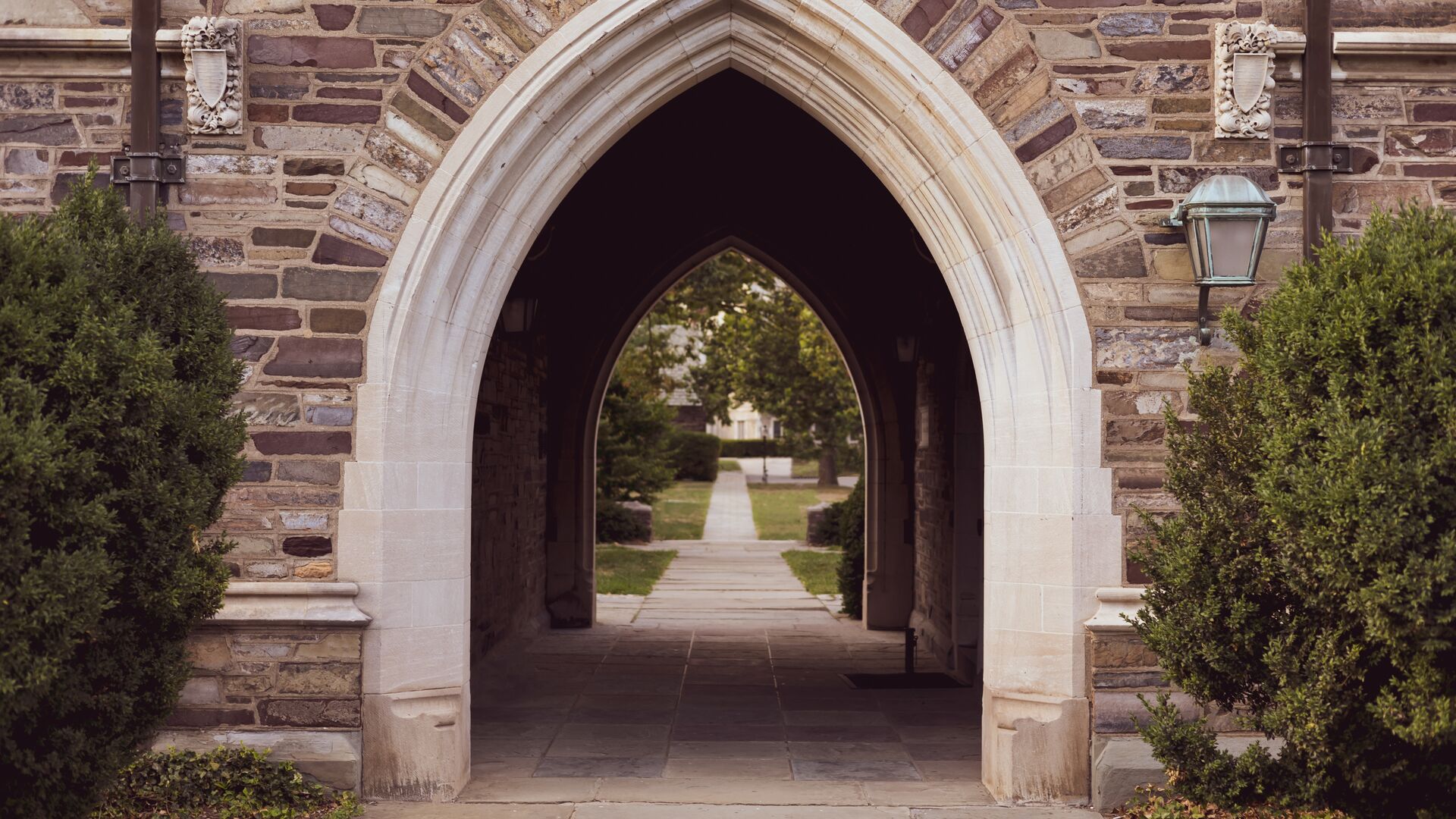 A bricked building with an arched tunnel walkway.