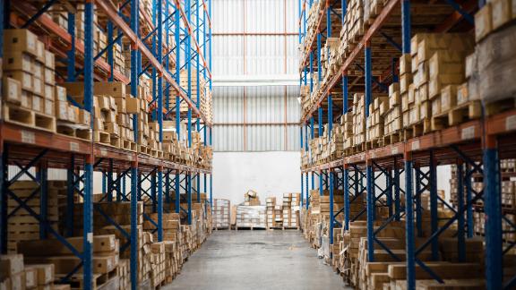 Distribution warehouse with metal shelves and pallets of boxes.