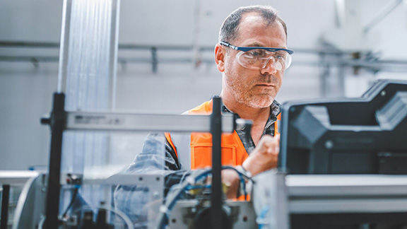 Professional industrial factory man employee working with machine parts.