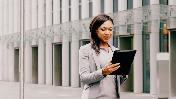 Professional business woman reading from her tablet in a financial district.