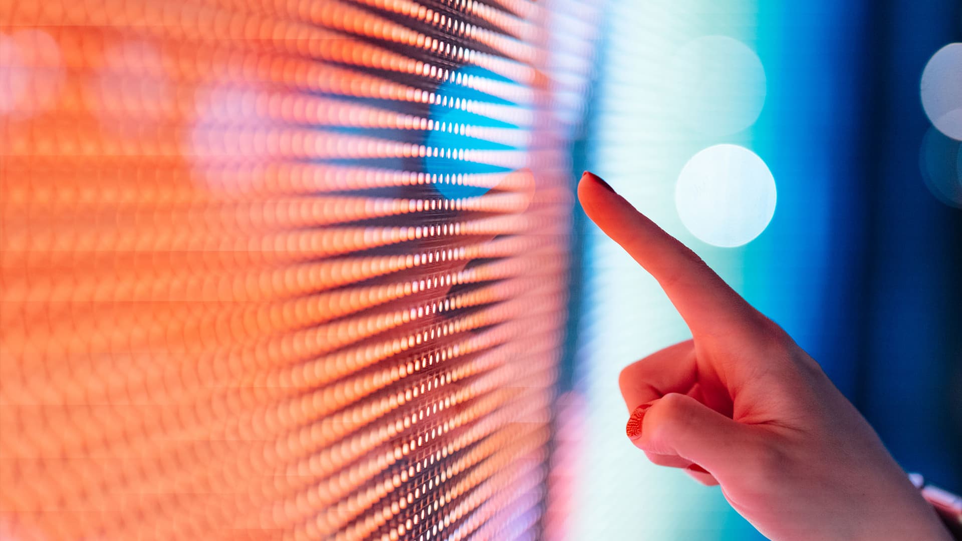 Someone pointing their finger at an illuminated digital screen