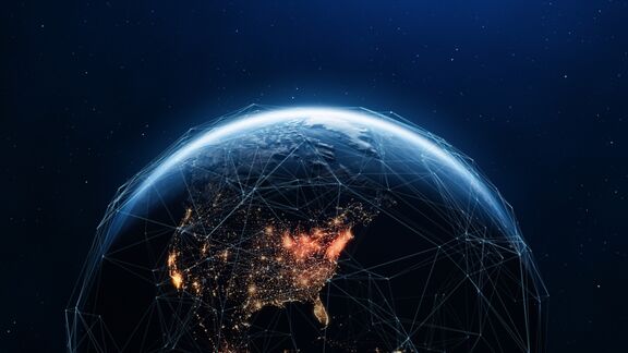 A 3D render of planet Earth with illuminated cities lights showing a digital network