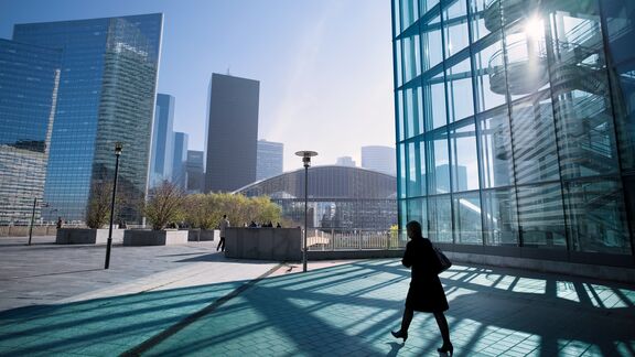 Silhouette of businesswoman walking towards center of business district in Paris, France.