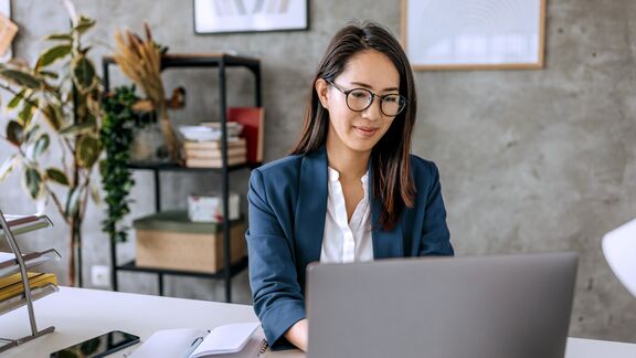 A business woman working from her home office on a laptop.