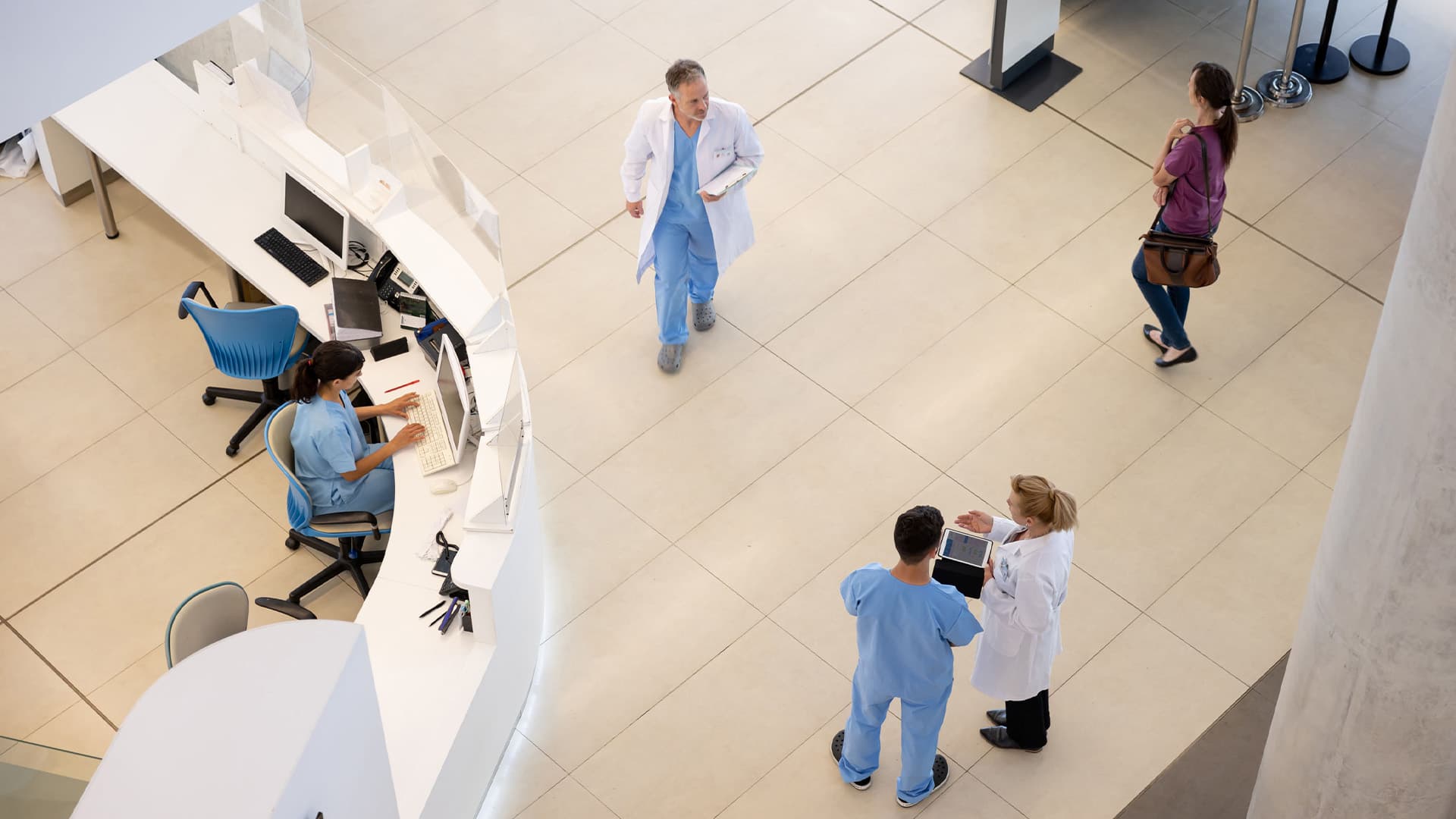 Doctors and nurses walking around the entrance hall of a hospital