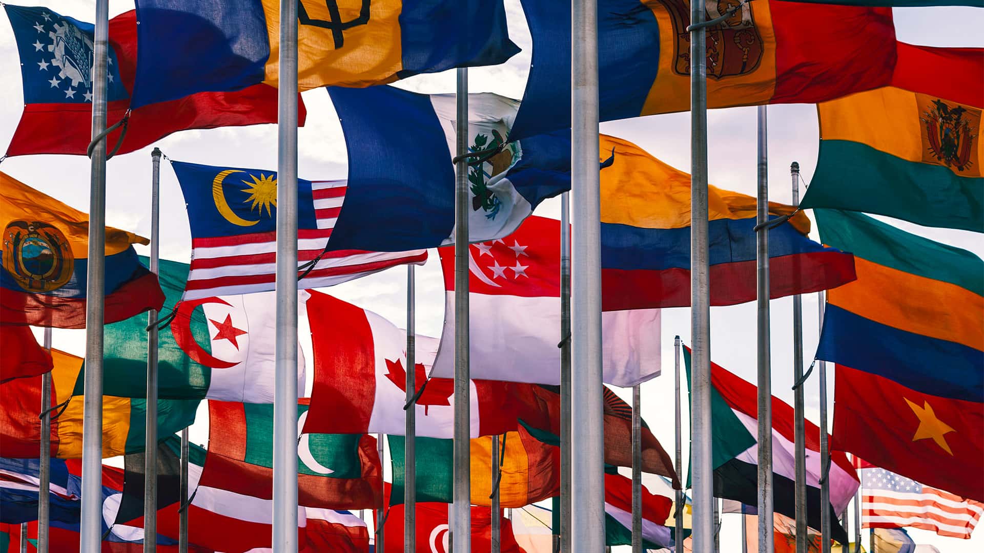 Flags of different nations waiving on high flagpoles