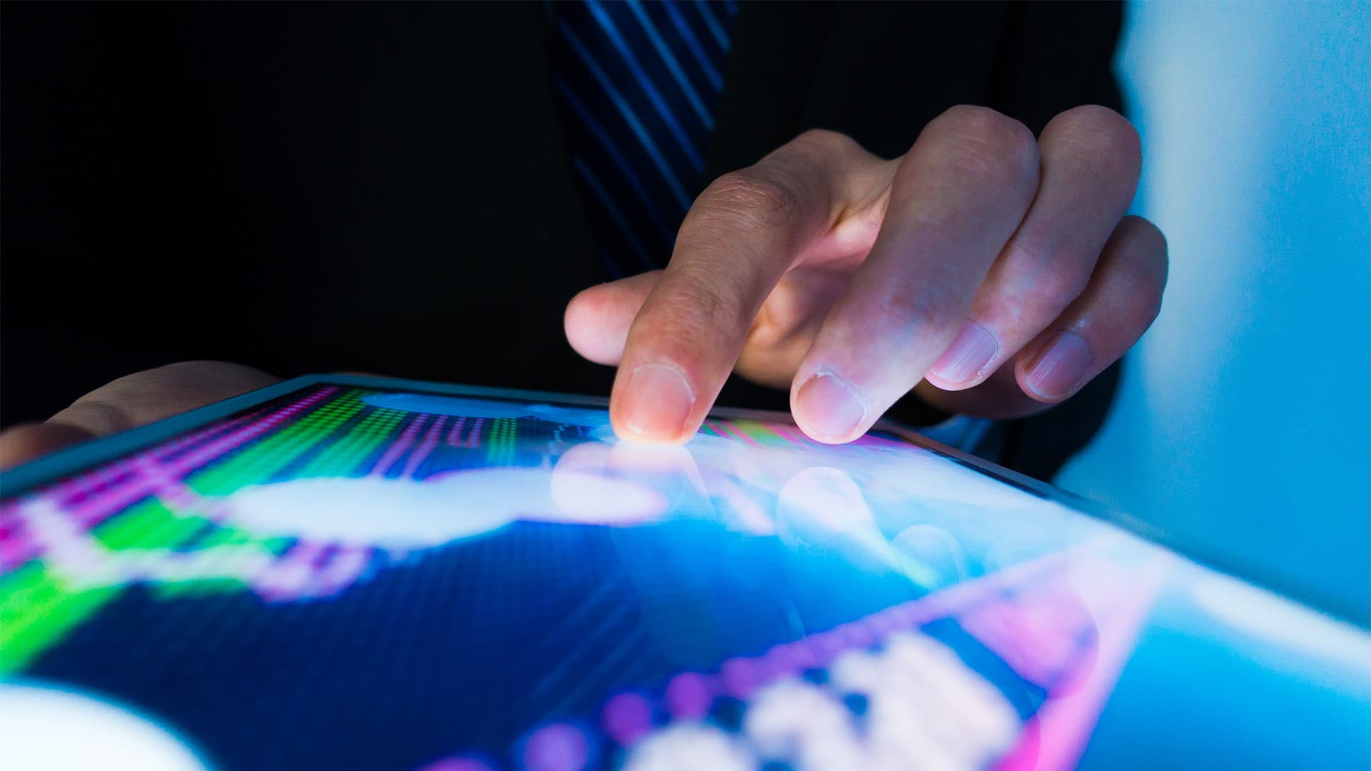 Close up of someones hand touching a tablet.