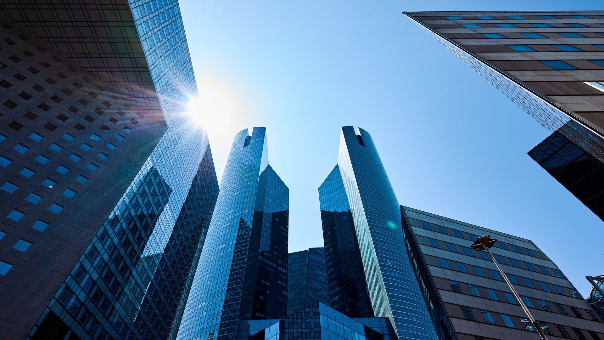 France, Paris, La Defense, low angle view of brightly lit modern office buildings in daytime