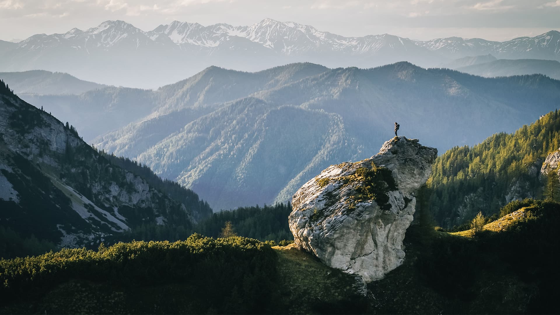 A person hiking a mountain while looking out in the distance