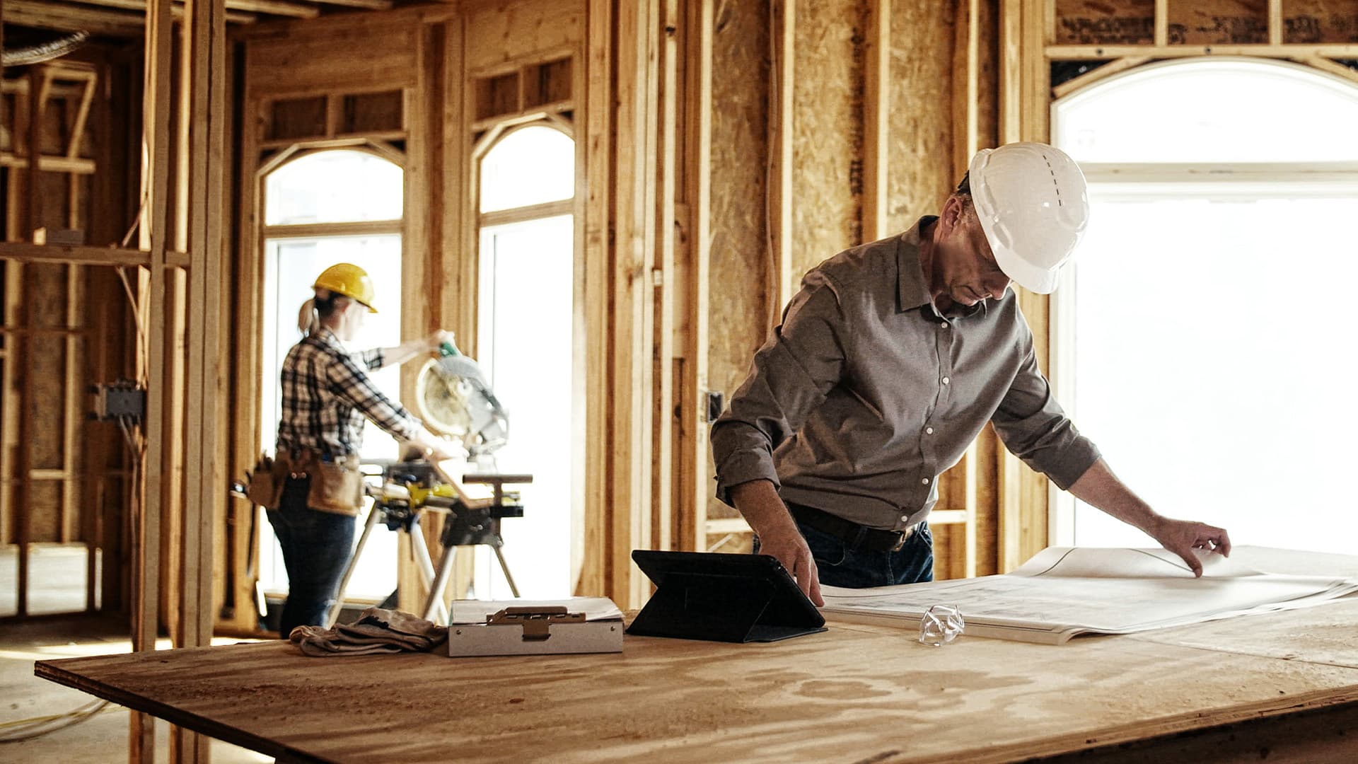 A construction worker using heavy machinery to cut metal.
