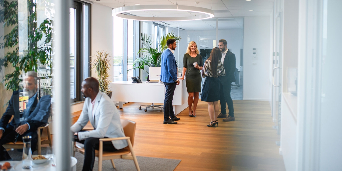 A group of colleagues smiling and enjoying coffee together.