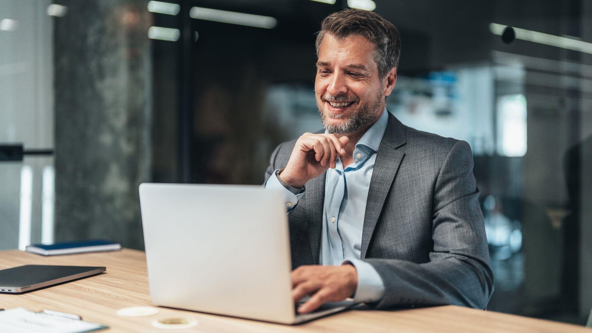 Financial industry professional tuning in to a virtual webinar at his desk.
