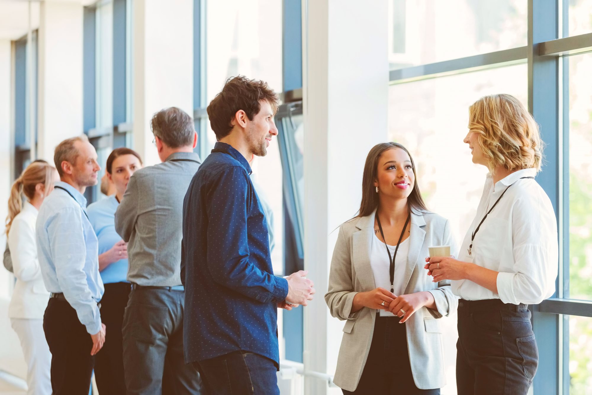 Colleagues gathered around chatting in a bright conference room.