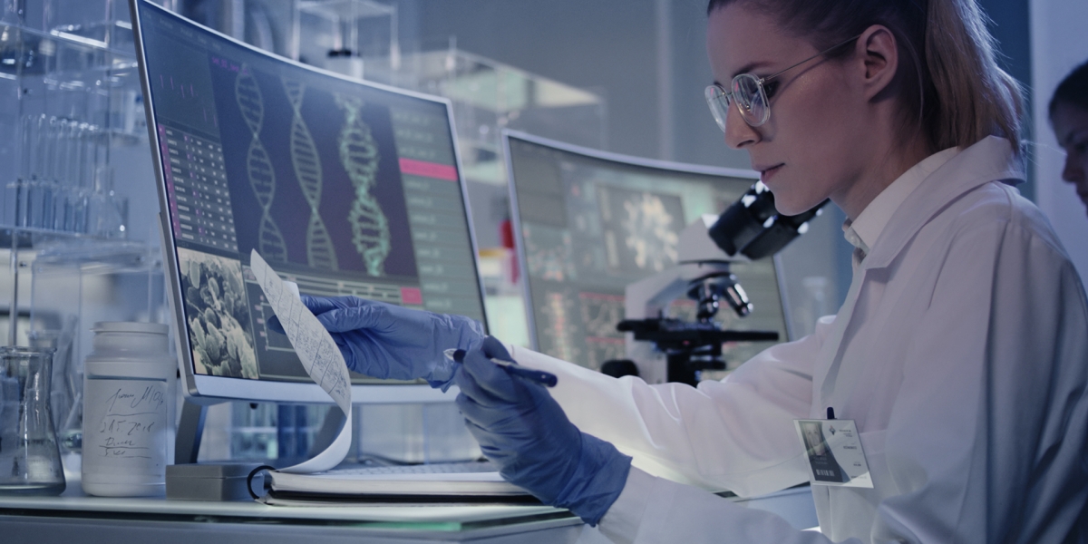A woman scientist in a lab, looking over documents about DNA research.