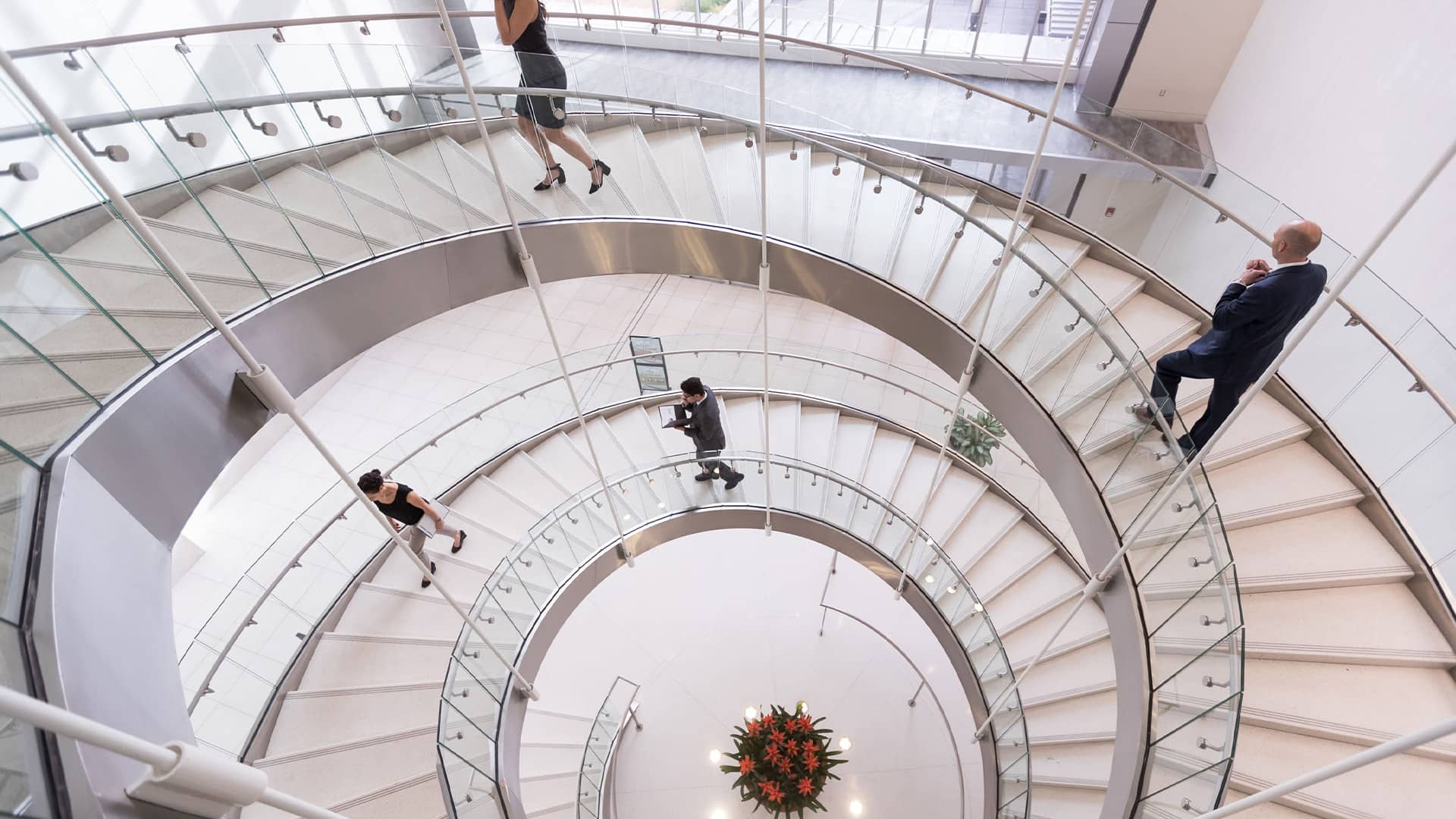 People who are walking up a spiral staircase at a conference center
