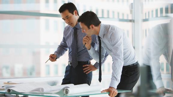 Two business professionals working closely on a project together.