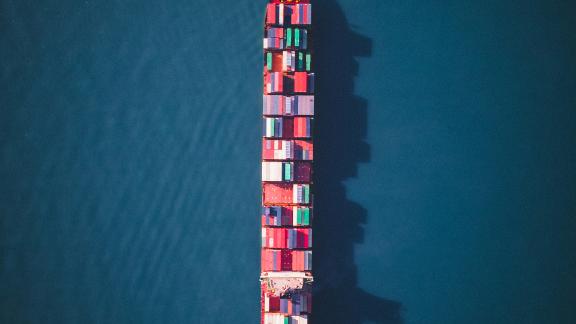 A large ship full of shipping containers in the ocean.