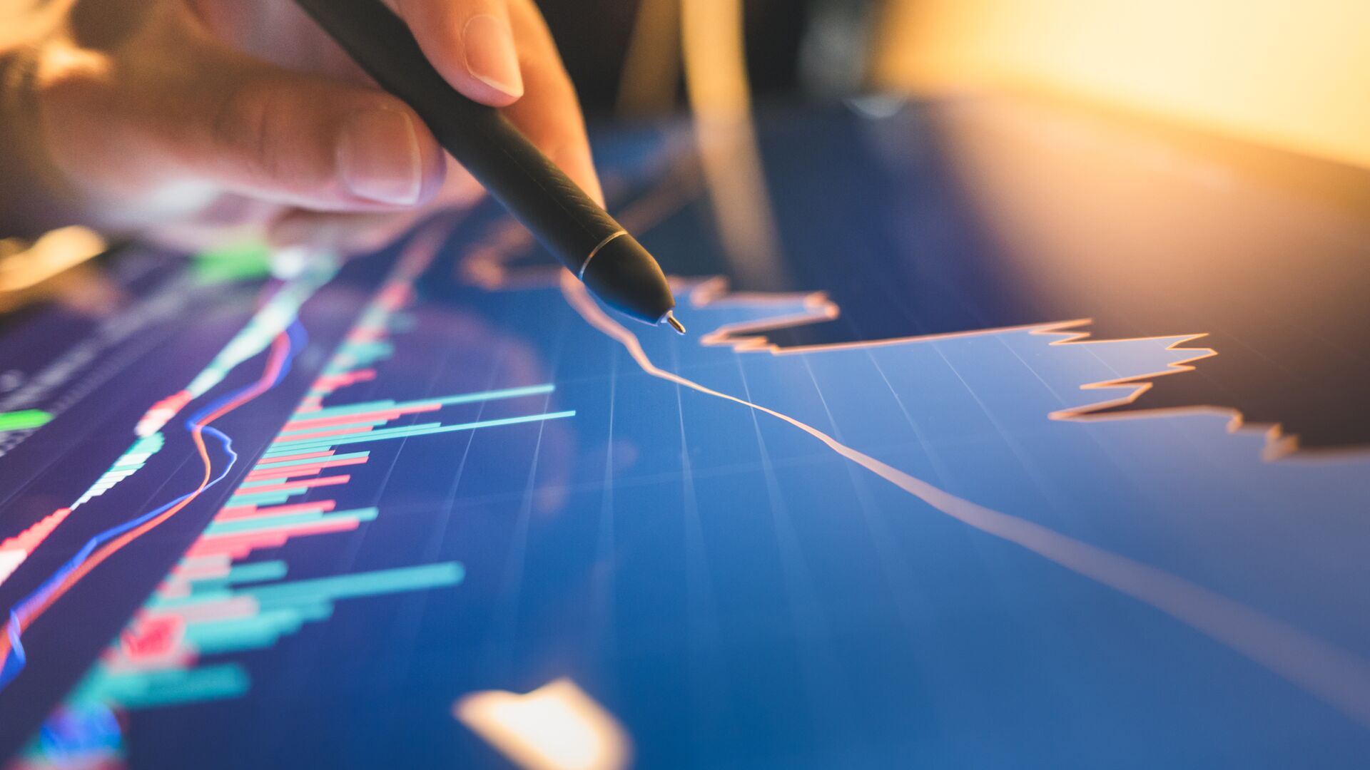 A person using a stylus on a digital tablet to analyze stock market and cryptocurrency data.