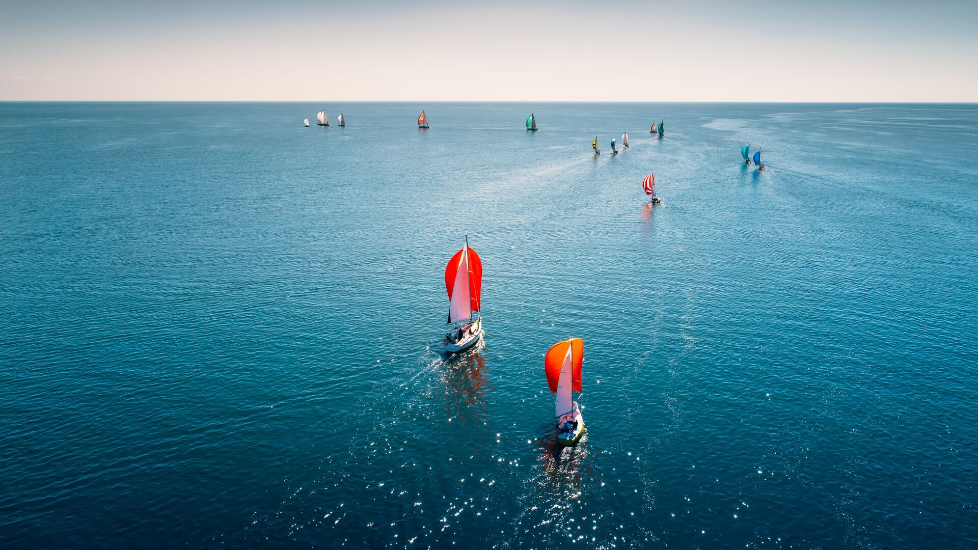 Sailboats sailing on a blue lake.
