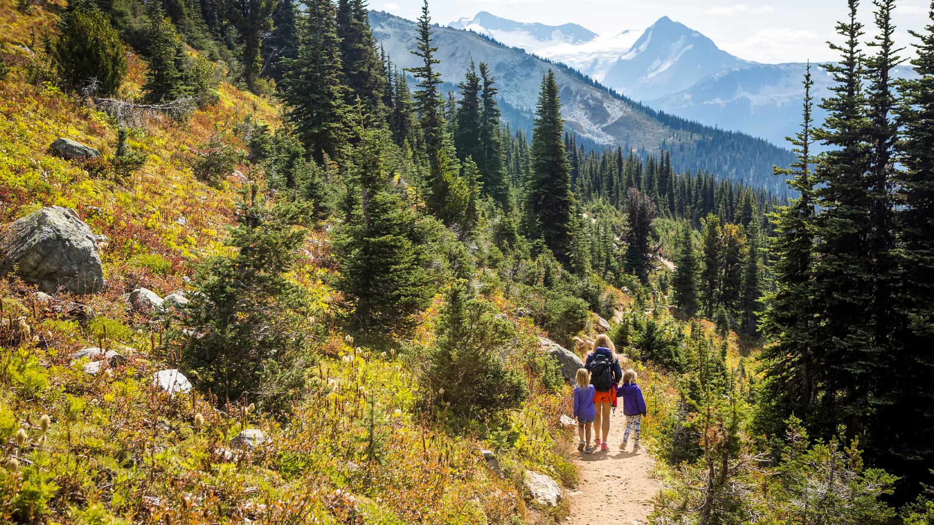 A mother who is hiking with her two daughters in the mountains