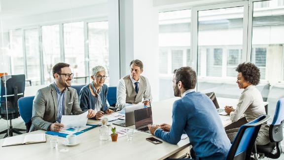 A group of people who are in a conference room and having a meeting.