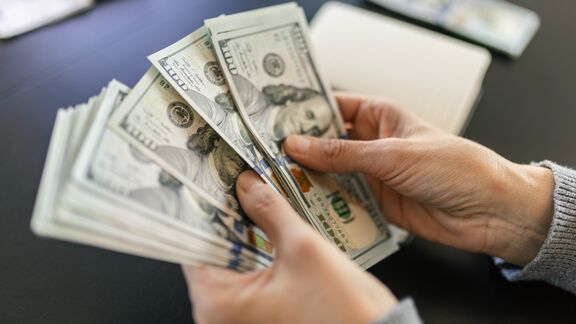 A person counting a hundred dollar bills.