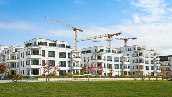 Row of white apartment houses and construction site