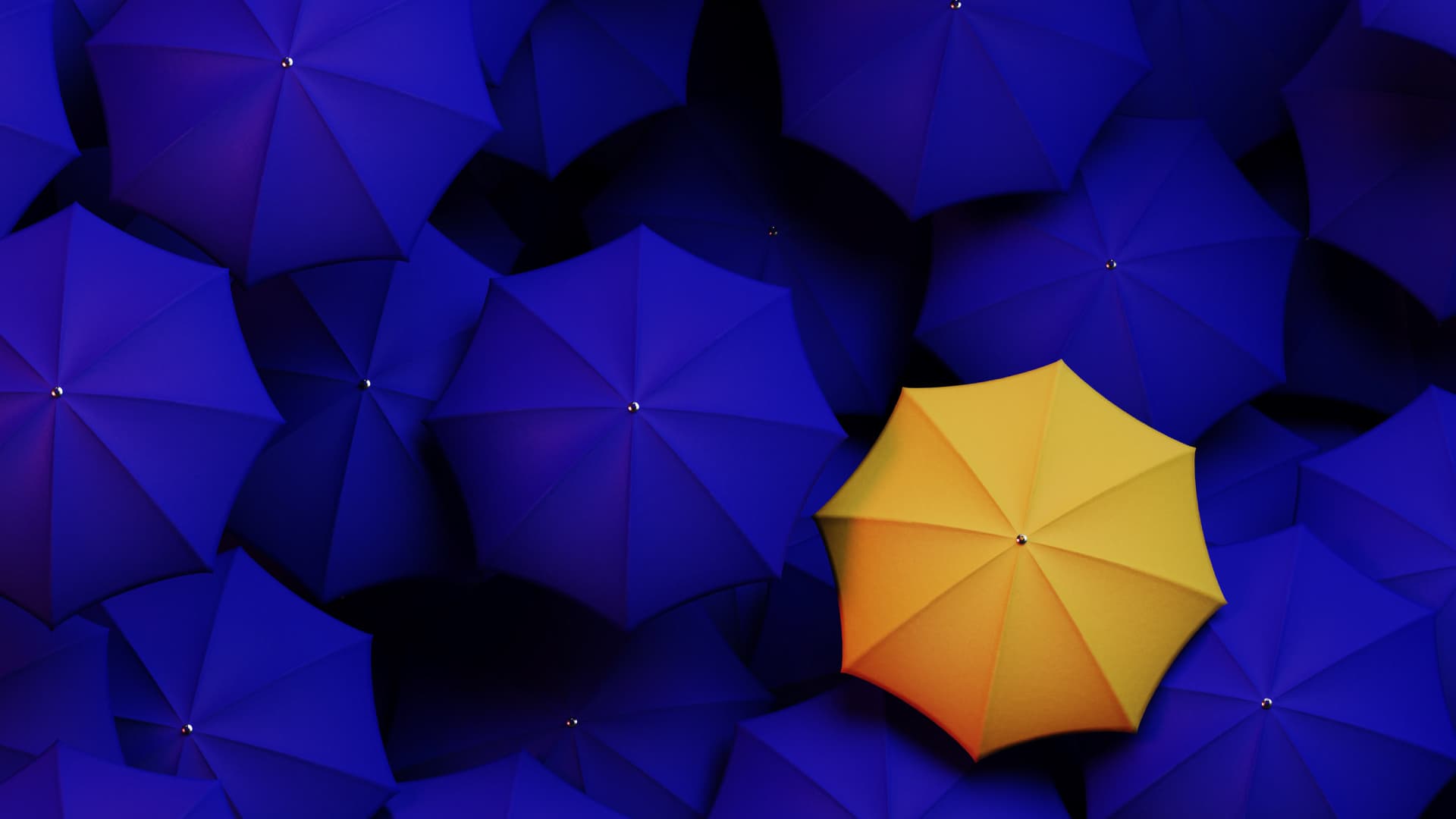 Large group of blue umbrellas with a single yellow umbrella standing out