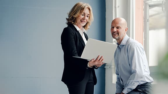 Two business professionals checking something out on a laptop.