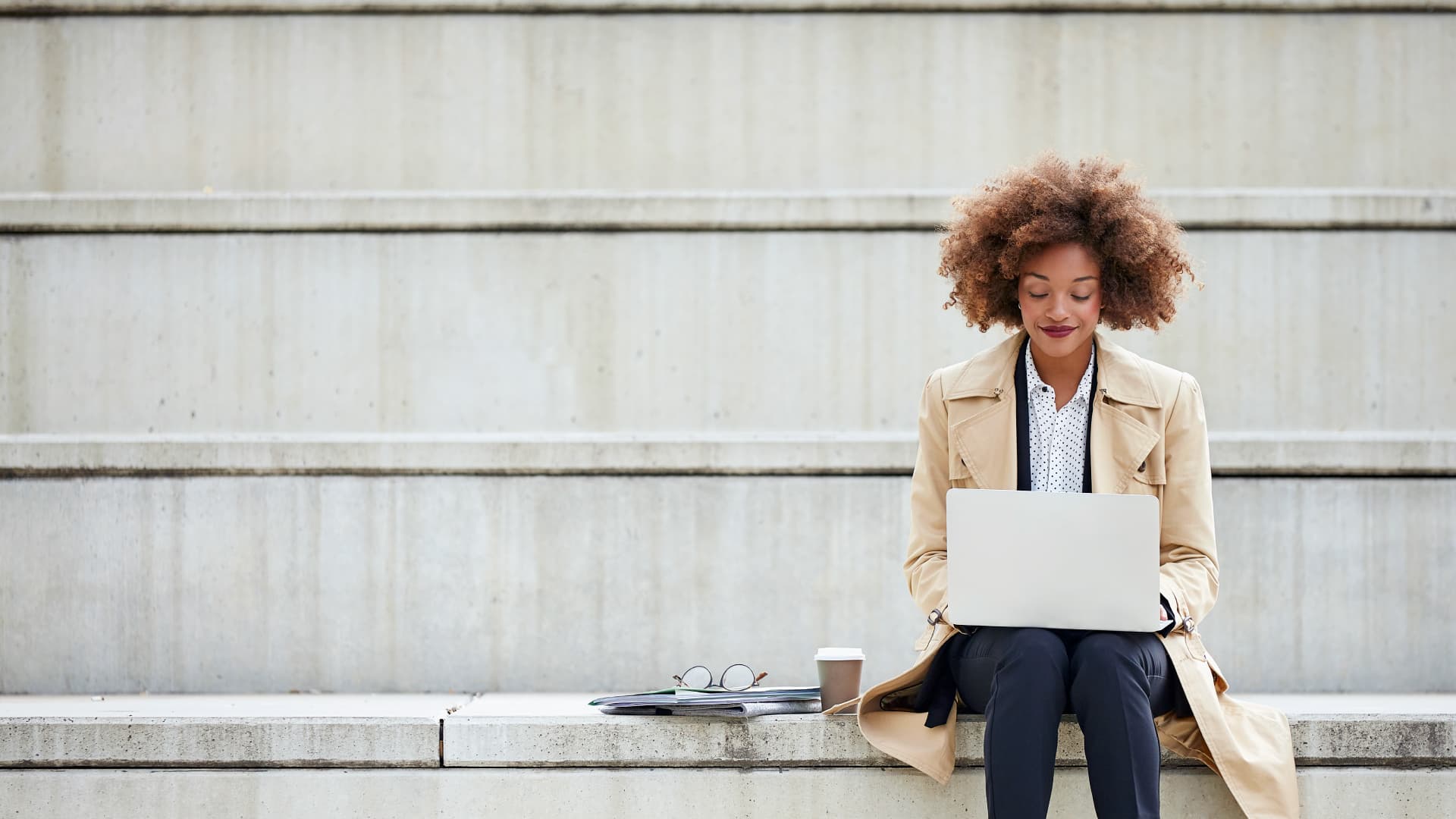 A student intern smiling while working on her laptop.