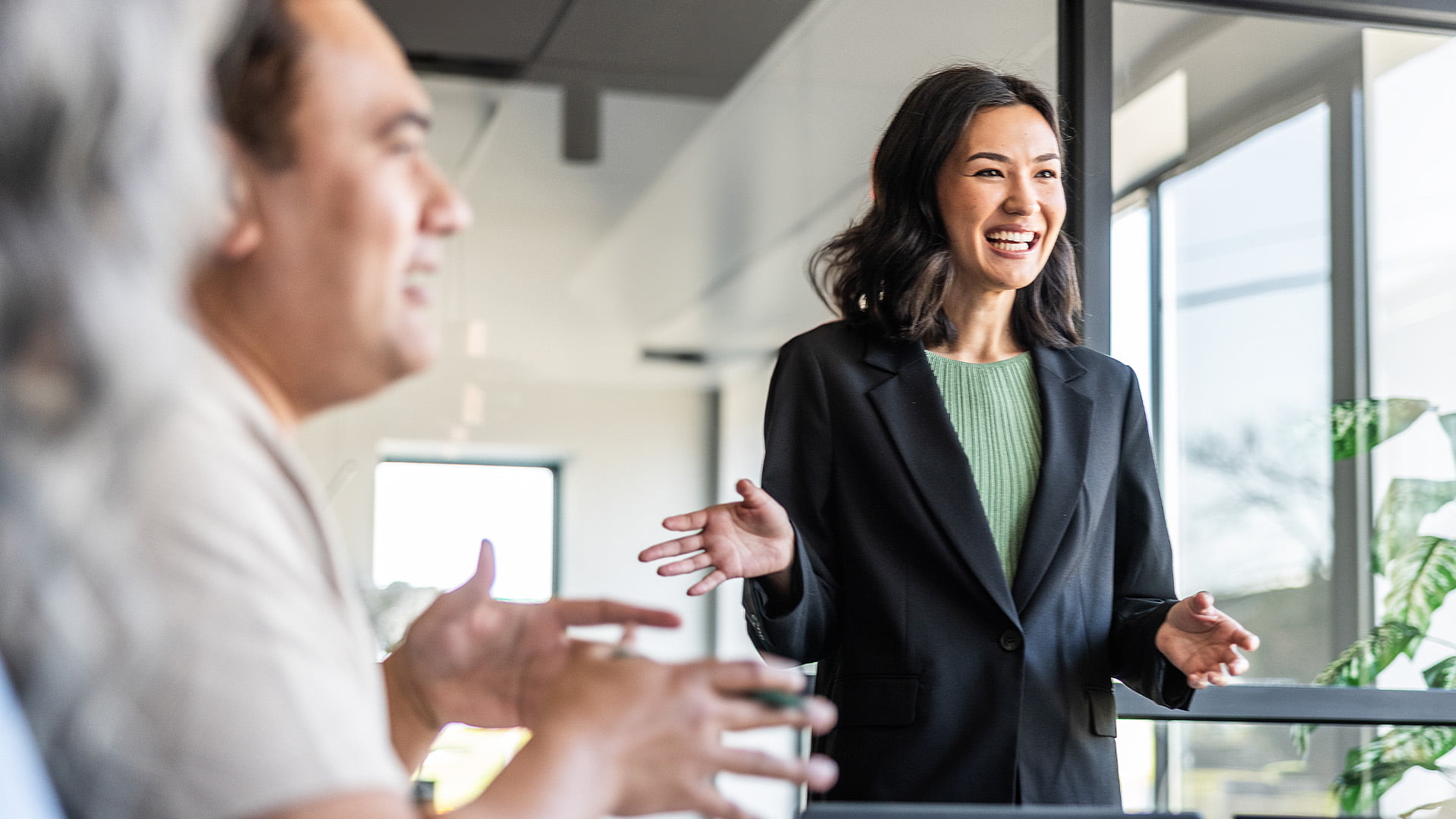 A businesswoman speaking to her colleagues in modern looking conference room