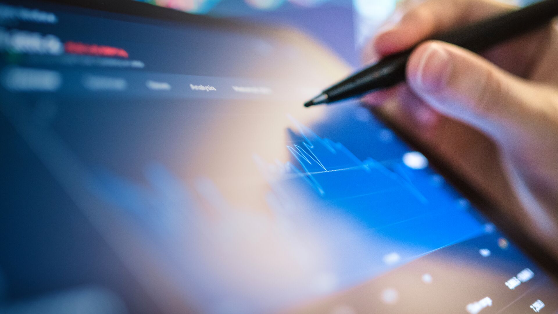 Hand holding a stylus interacting with a tablet displaying a digital chart.